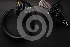 Podcasts and Stream. Flat lay. Studio condenser microphone black with professional headphones