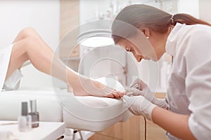 Podiatrist painting nails and making procedure for foot.