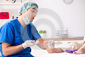 The podiatrist treating feet during procedure