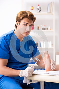 The podiatrist treating feet during procedure