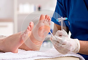 Podiatrist treating feet during procedure