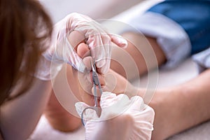 Podiatrist treating feet during procedure