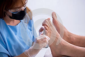 Podiatrist treating feet during procedure