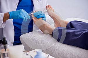 Podiatrist treating feet during procedure