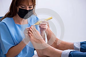 Podiatrist treating feet during procedure