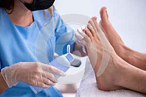 Podiatrist treating feet during procedure