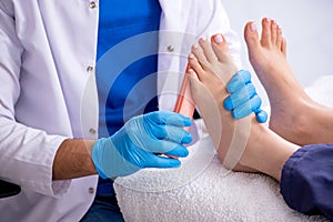 Podiatrist treating feet during procedure