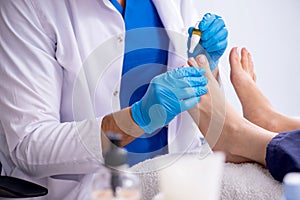 Podiatrist treating feet during procedure