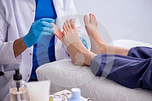 Podiatrist treating feet during procedure