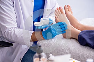 Podiatrist treating feet during procedure