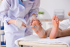 The podiatrist treating feet during procedure