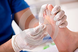 The podiatrist treating feet during procedure