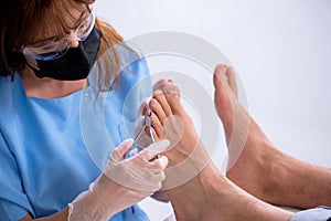 Podiatrist treating feet during procedure