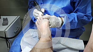 Podiatrist in white gloves clean with cotton a toenail. Concept of podology and chiropody.