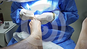 Podiatrist in white gloves clean with cotton a toenail. Concept of podology and chiropody.