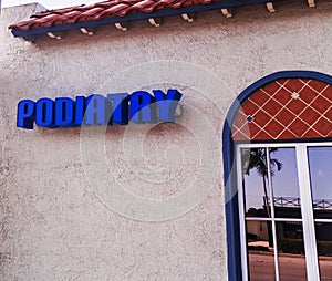 Podiatry Doctor Sign in Blue Letters On the Front of a Building