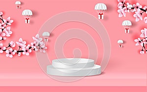 Podium on pink Background. Parachute gift box fly air in holiday sky. Paper cut and craft. winter snowfall season with Sakura