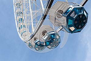 The pods of the Ferris wheel fly in the sky