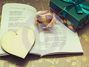 A poem, a wooden heart, dried roses and a box with a gift