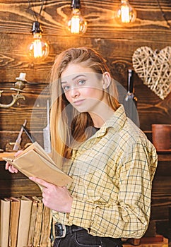 Poetry evening concept. Girl in casual outfit in wooden vintage interior enjoy poetry. Girl reading poetry in warm