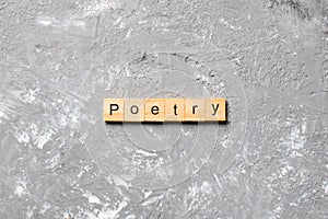 Poetry word written on wood block. Poetry text on cement table for your desing, Top view concept