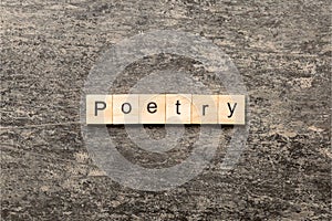 Poetry word written on wood block. Poetry text on cement table for your desing, Top view concept