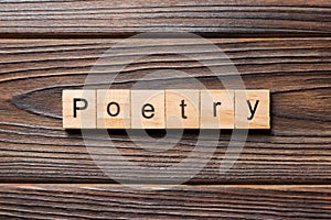 Poetry word written on wood block. Poetry text on wooden table for your desing, Top view concept