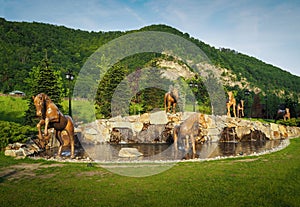 Poiana lui Caliman Park in Caciulata, Romania. Artesian well with horse statues. photo