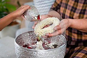 Point of view of child pouring water on hands of elder senior or respected grandparents