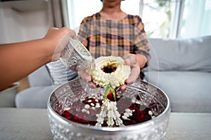 Point of view of child pouring water on hands of elder senior or respected grandparents