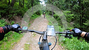 Point of view. Cyclist riding electric mountain bikes outdoors.