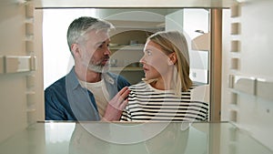 Point of view POV from inside refrigerator adult middle-aged family couple woman man mature husband wife open empty