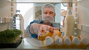 Point of view POV from inside refrigerator fridge middle-aged Caucasian man buyer customer unpack food delivery shopping