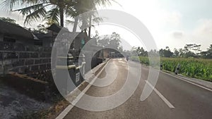 Point of view POV shot of men riding classic motorcycle, with village view