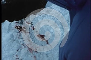 Point of view shot of bloodstains on a snowy cliff