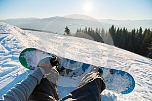 Point of view shot of a female snowboarder lying on the snow on the slope relaxing after riding