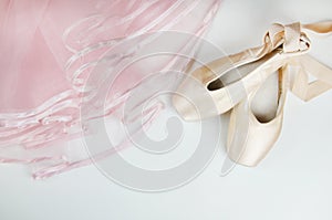 Pointe shoes and a pink tutu on a white background