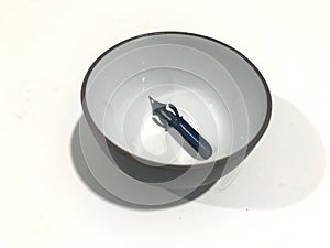 Pointed nib inside an ink bowl photo