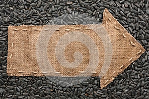 Pointer of burlap lies on sunflower seeds