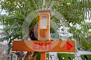Pointer Exit with a lantern on a background of a palm tree