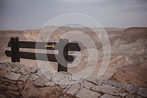 A pointer sign on the hill in sand desert