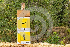 Pointer on a wooden board in a campsite, toilet and shower sign