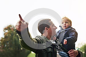 Pointing, dad and kid in nature with happy fun, showing and bonding in outdoor garden. Father, son and playful learning