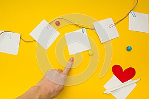 Pointing the finger at a piece of paper, place for text, yellow background