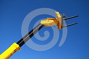 Pointing forklift against the sky