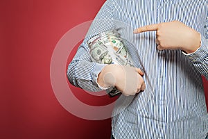 Pointing hand and money us dollars in jar on pink background