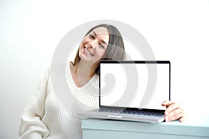 Pointing laptop screen, portrait of caucasian woman pointing laptop screen. Woman holding modern laptop with empty blank