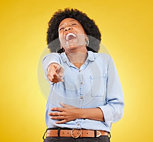 Pointing, laughing and fun with a black woman in studio on a yellow background enjoying a funny joke. Comic, comedy and