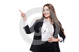 Pointing and looking to the side. Casual young business woman looking, pointing and smiling at copy space.