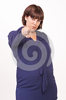 Pointing the way to success. Portrait of a pretty young brunette woman pointing her finger at you on a white background.